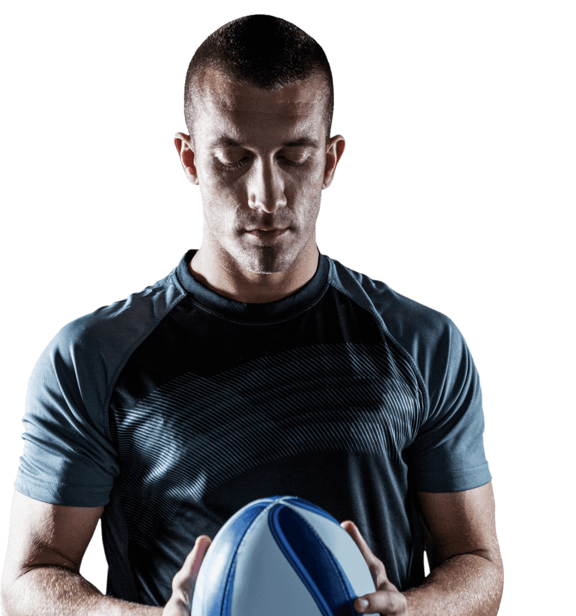 rugby player serenly holds the ball in front of him with his eyes closed as though he's preparing for something